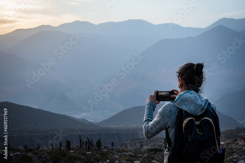 Mujer turista tomando una foto en los cerros de Tilcara, Jujuy, Argentina photo