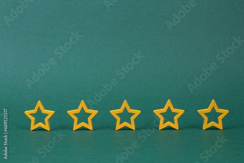 Gold, gray, silver five stars shape on a green background. The best excellent business services rating customer experience concept. Increase rating or ranking, evaluation and classification idea.