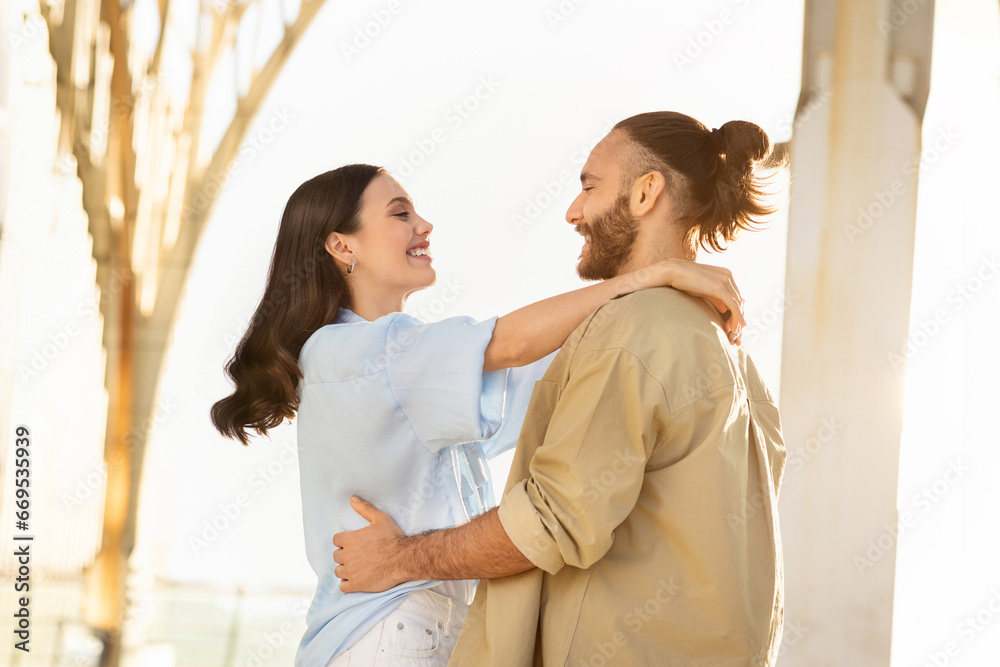 Happy millennial european guy in casual meets lady, hugs at station or airport Happy millennial european guy in casual meets lady, hugs at station or airport