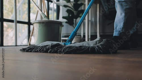 Housewife using vacuum cleaner on the floor. Wearing an apron to clean the living room at house. Young woman is happy to clean home. Maid cleaning service. photo