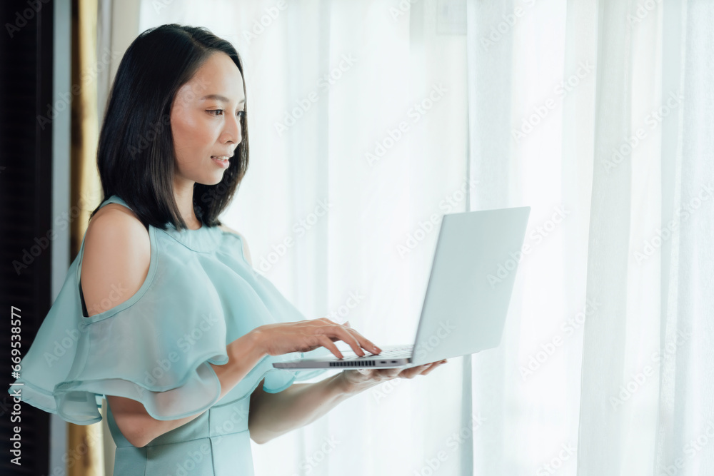 Asian businesswoman head of the company Working in the office room with a white laptop in front of him I'm typing my work intently. Wear a light green dress. for quality work in the future Asian businesswoman head of the company Working in the office room with a white laptop in front of him I'm typing my work intently. Wear a light green dress. for quality work in the future