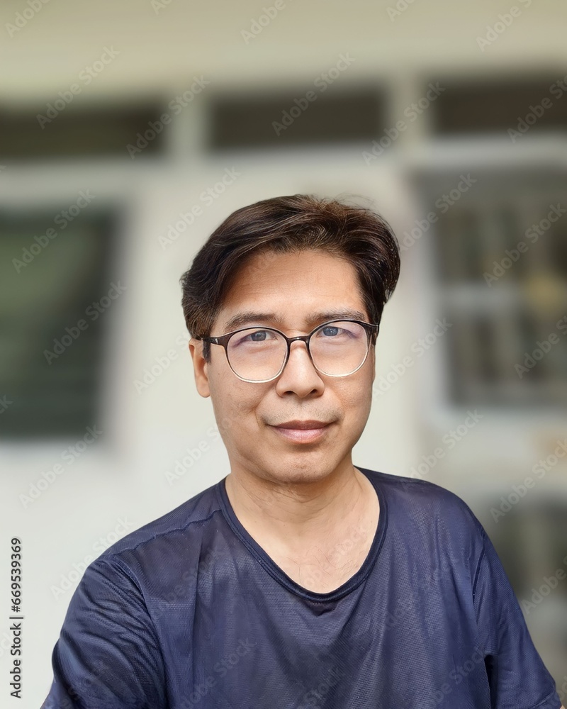 Smartphone selfie of a man wearing glasses in a dark blue round neck t-shirt. Smartphone selfie of a man wearing glasses in a dark blue round neck t-shirt.
