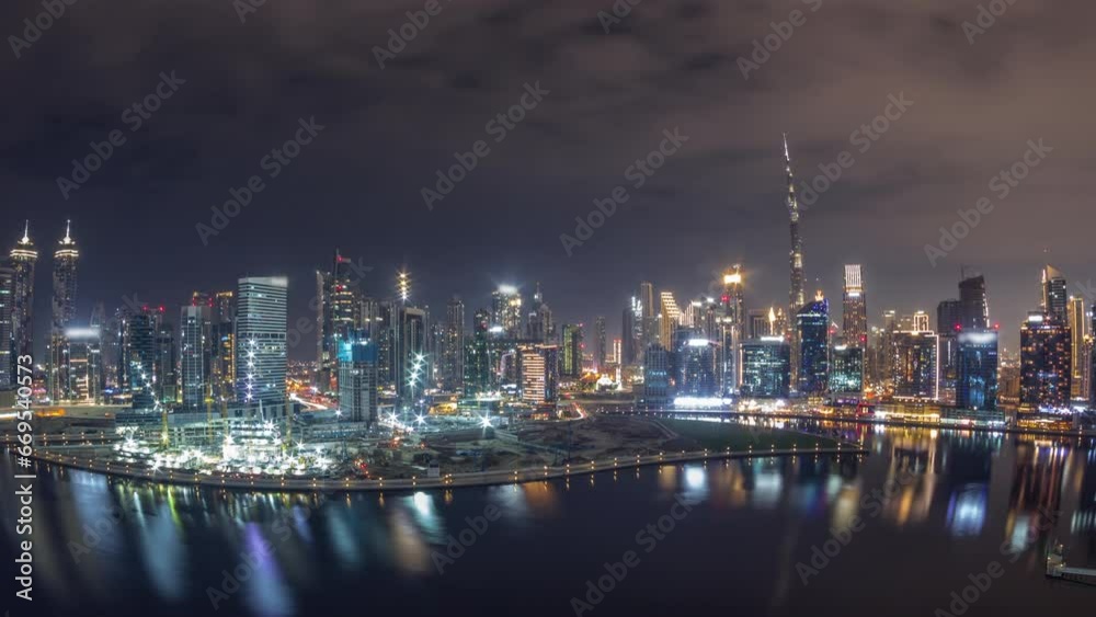 Aerial panorama of Dubai Business Bay and Downtown during all night with the various skyscrapers and towers along waterfront on canal night timelapse. Construction site with cranes covered by fog Aerial panorama of Dubai Business Bay and Downtown during all night with the various skyscrapers and towers along waterfront on canal night timelapse. Construction site with cranes covered by fog