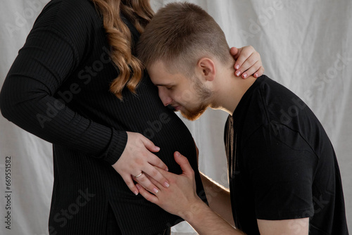Man kissing pregnant belly, close-up