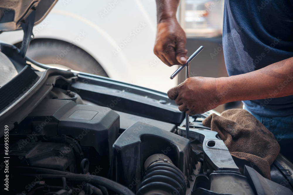 Close up Car Mechanic man hands repairing car auto repair shop. Man hands fixing machinery vehicle mechanical service. open vehicle hood checking up auto mobile. Vehicle Car maintenance engineer. Close up Car Mechanic man hands repairing car auto repair shop. Man hands fixing machinery vehicle mechanical service. open vehicle hood checking up auto mobile. Vehicle Car maintenance engineer.