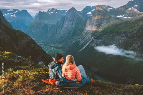 Couple in love hiking together romantic vacations with travel camping gear, Man and woman in sleeping bags enjoying mountains landscape outdoor family healthy lifestyle friends exploring Norway photo