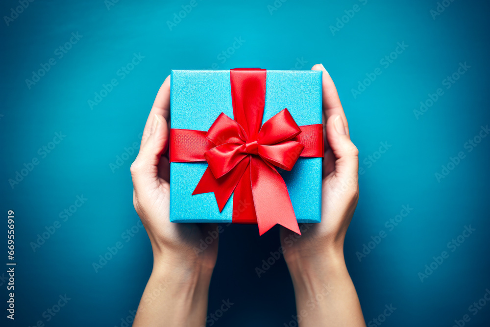 close up of woman hands holding christmas gift box over blue background close up of woman hands holding christmas gift box over blue background