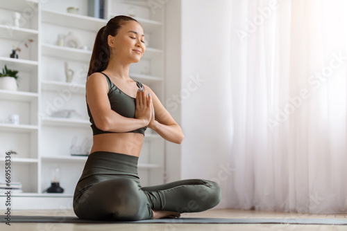 Fototapeta Naklejka Na Ścianę i Meble -  Morning Yoga. Portrait Of calm young asian woman meditating at home