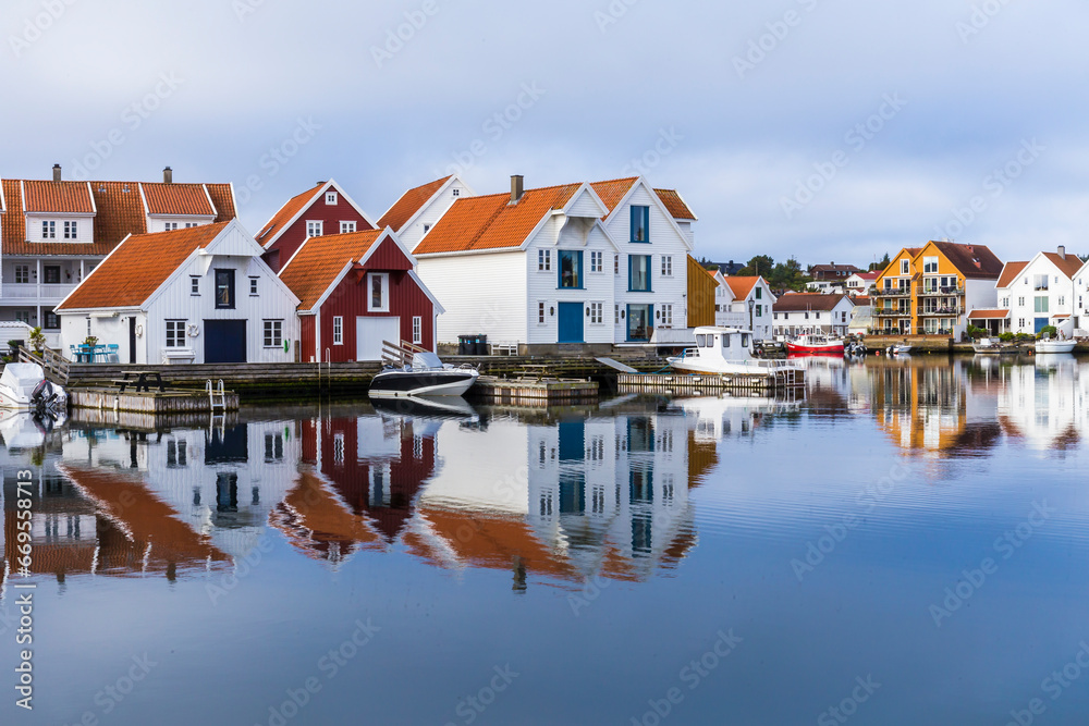 Houses and boats are reflected in the water - obrazy, fototapety, plakaty 