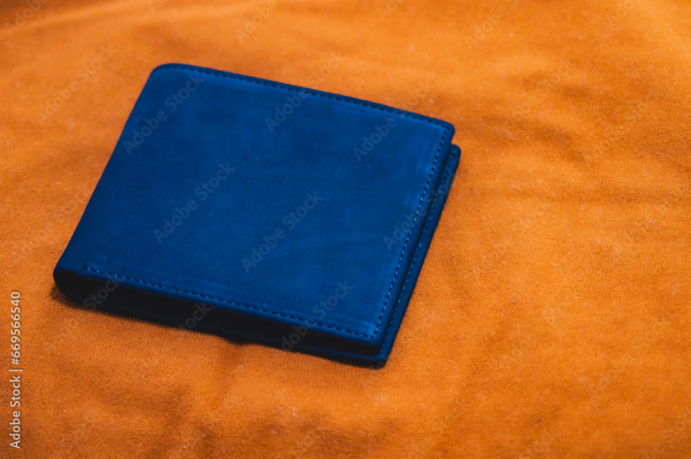 Blue handmade leather wallet on a brown velvet background. Top view. Blue handmade leather wallet on a brown velvet background. Top view.
