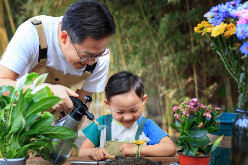 Father and son are trimming flowers and plants in the yard