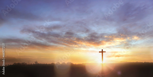 Christian wooden cross on sunset background