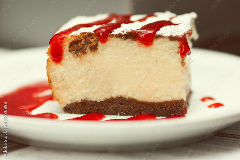 Tasty morning concept. Slice of cheese cake with sugar powder and strawberry jam in cafe. Daylight. Close up. Outdoor shot Tasty morning concept. Slice of cheese cake with sugar powder and strawberry jam in cafe. Daylight. Close up. Outdoor shot