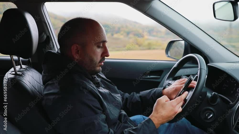A man in a car is typing a message on his phone. High quality FullHD footage A man in a car is typing a message on his phone. High quality FullHD footage