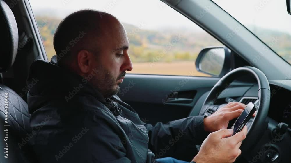 A man in a car is typing a message on his phone. High quality FullHD footage A man in a car is typing a message on his phone. High quality FullHD footage