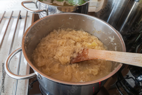Sauerkraut in a pot on the stove. There is cumin in cabbage