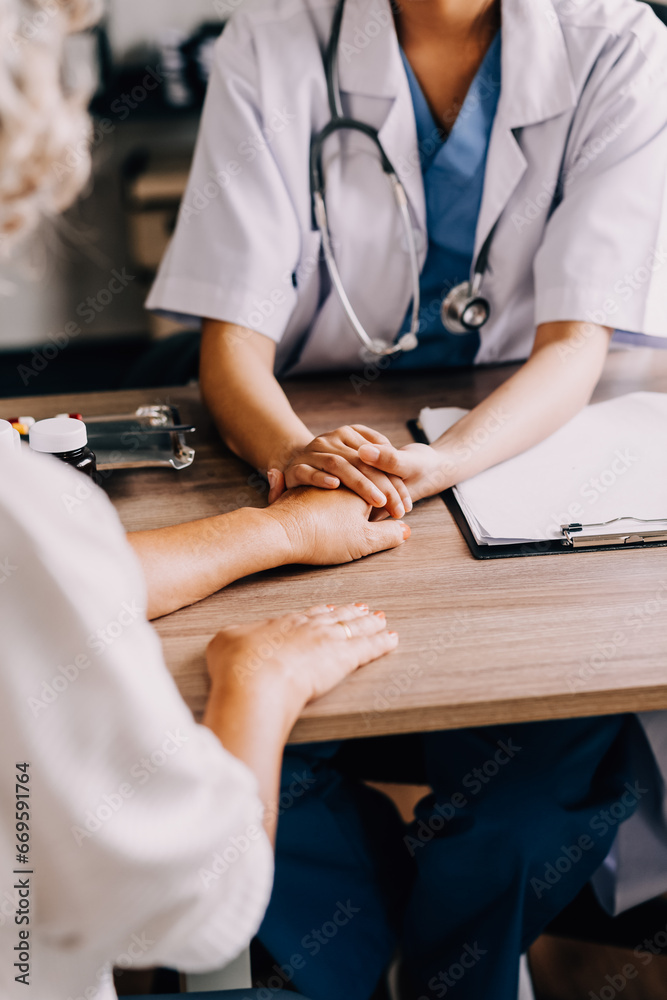 Obraz premium Doctor giving hope. Close up shot of young female physician leaning forward to smiling elderly lady patient holding her hand in palms. Woman caretaker in white coat supporting encouraging old person