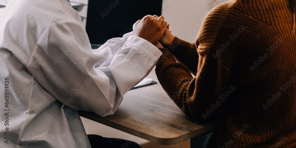 Young psychologist holding hand of her patient in need while consulting her after discussion of problem