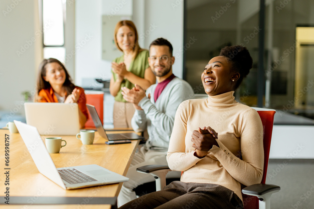 Cute Africam American woman with her young multiethnic startup team working in the modern office