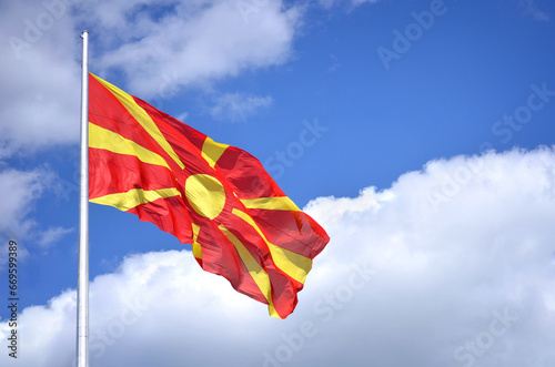 Macedonian Flag - It portrays a yellow sun with rays on a red background. The eight rays extend from the middle towards the margin as they broaden, representing “the new sun of liberty.” photo