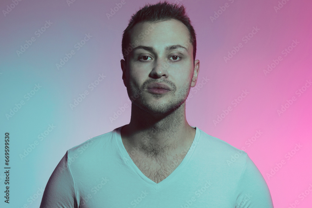 Fototapeta premium King of the hill concept. Close up portrait of stylish young man in neon lights with domineering. Retro, vintage style. Studio shot