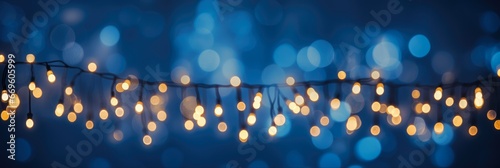 Glowing Christmas Lights Bokeh over Dark Blue Background. Holiday Decoration and Illumination Concept