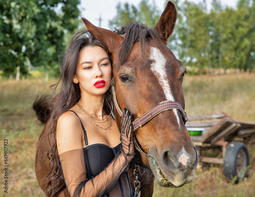 Beautiful young caucasian woman standing near the horse. © Panama