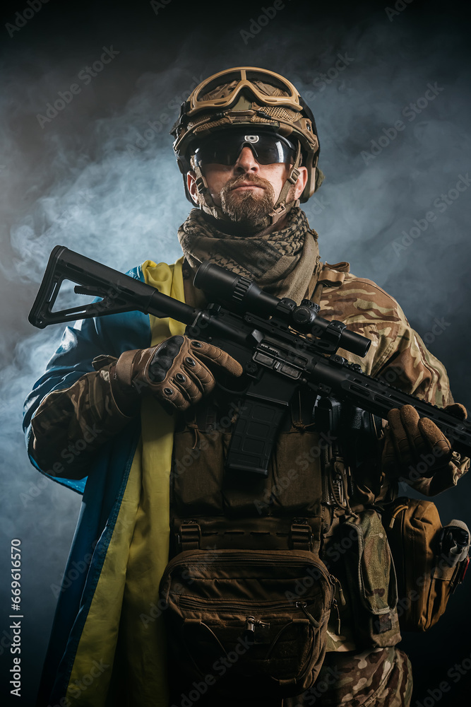 Private security contractors, elite special forces, Ukrainian soldier with full protection and Ukrainian flag in a combat zone. The concept of a strong country and invincible people. Private security contractors, elite special forces, Ukrainian soldier with full protection and Ukrainian flag in a combat zone. The concept of a strong country and invincible people.