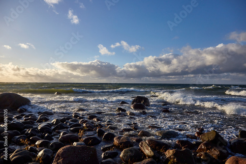 Windy day on the seashore with waves on the sea and cloudy sky above, selective focus