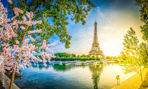 Paris Eiffel Tower and river Seine with sunrise sun in Paris, France. Eiffel Tower is one of the most iconic landmarks of Paris, panorama with sunshine