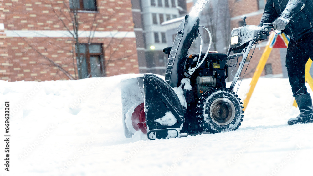 the janitor removes snow with a snow plow