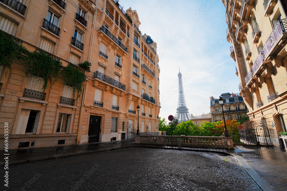 cosy Paris street with view on the famous Eiffel Tower on a cloudy summer day, Paris France