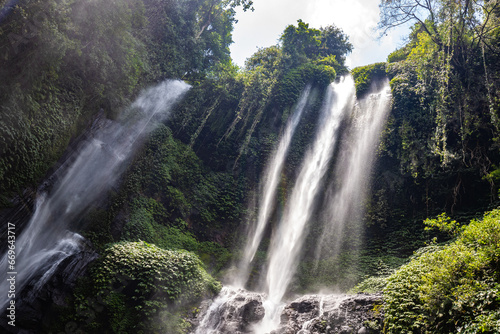 The Sekumpul Waterfall  a large waterfall in the middle of the jungle that falls into a deep green gorge. Trees and tropical plants at Bali s highest waterfall.