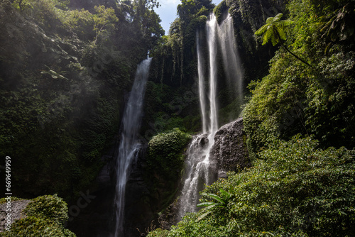 The Sekumpul Waterfall, a large waterfall in the middle of the jungle that falls into a deep green gorge. Trees and tropical plants at Bali's highest waterfall.