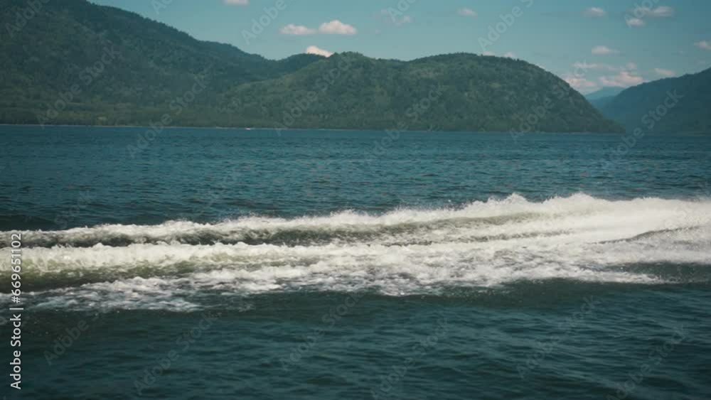 Heavy yacht trail with foam and splashes on ocean water slow motion. Boat trace on sea surface against hilly island at tropical resort. Seaside beauty Heavy yacht trail with foam and splashes on ocean water slow motion. Boat trace on sea surface against hilly island at tropical resort. Seaside beauty