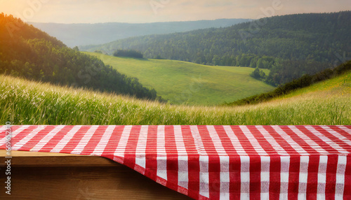 wooden table is covered with red tablecloth background is blurred perfect day for picnic nature dining
