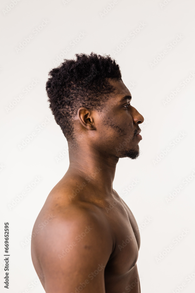 Fototapeta premium Serious african american guy profile portrait naked. Man looking aside on white studio background