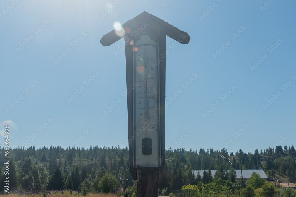 mercury thermometer on the street on a hot day against the background of the forest sun and blue sky mercury thermometer on the street on a hot day against the background of the forest sun and blue sky