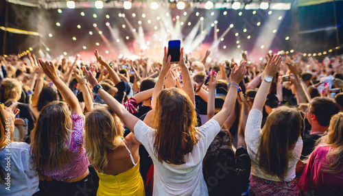 a crowd of people at a live event concert or party holding hands and smartphones up large audience crowd or participants of a live event venue photo