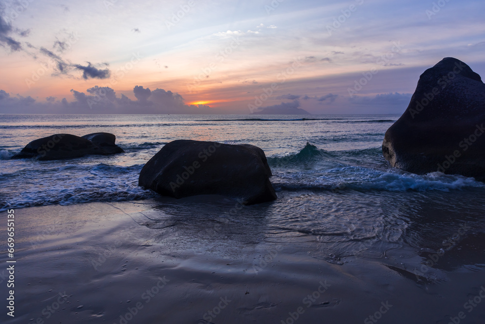 Silhouettes of coastal rocks at sunset. Mahe island, Seychelles
