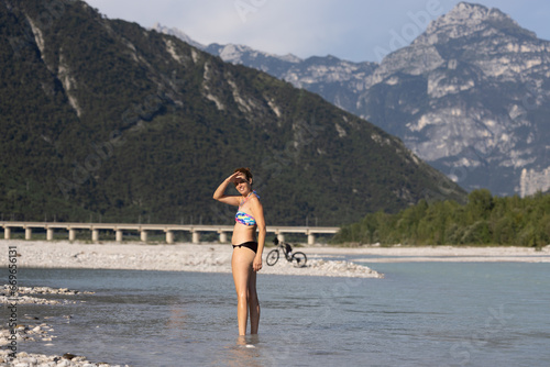 Tableau sur toile Adult Woman Cycled to the near River for a Refreshment in Summer - Carnia Italy
