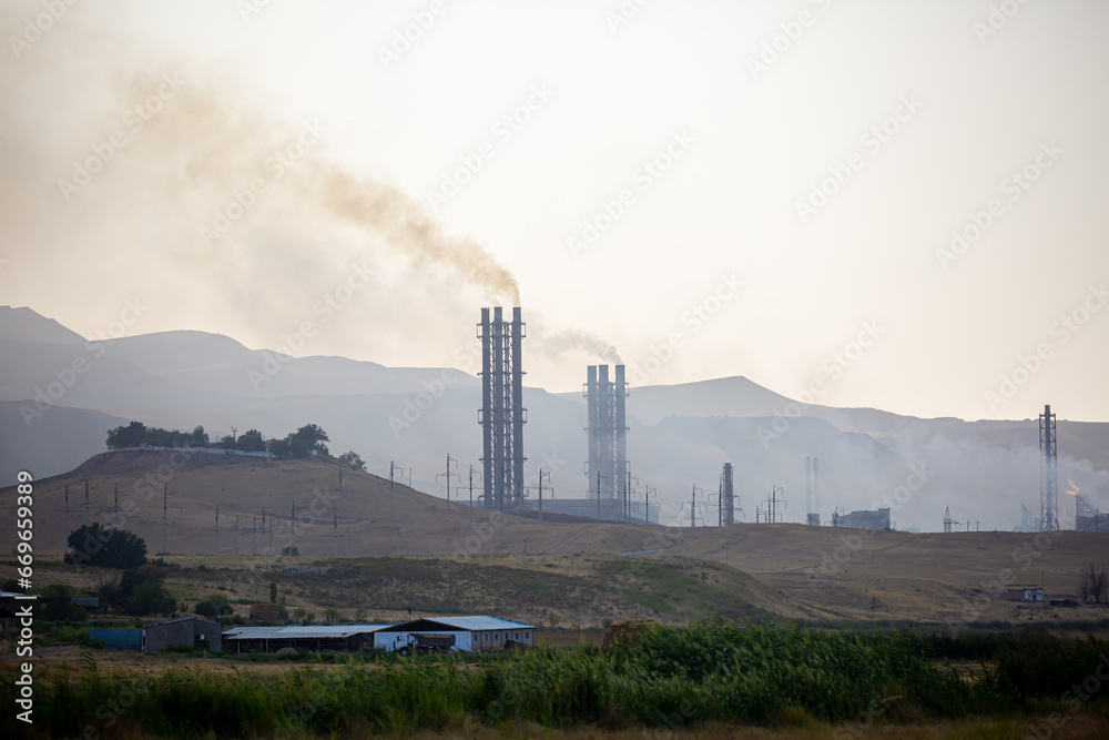Working factory. Smoke from the factory chimney. Ecological pollution. Air emissions polluting the city. Industrial waste is hazardous to health. Large factory in smog, Production in operation.