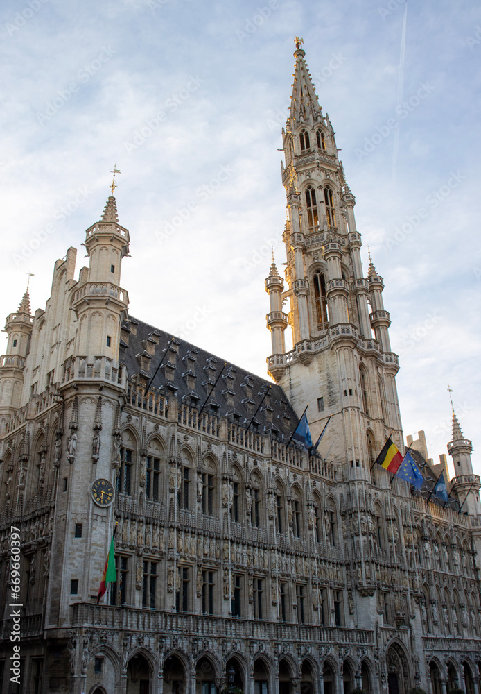Sweeping View of Brussels Town Hall with Clock Tower and Trio of Flags - Grand Place's Gothic Jewel Sweeping View of Brussels Town Hall with Clock Tower and Trio of Flags - Grand Place's Gothic Jewel