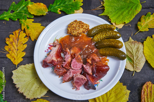 Autumn seasonal delicacy from region of former Austrian - Hungarian monarchy in central Europe. Smoked and slowly roasted pork knuckle with pickles and mustard served in Prague, Budapest or Wiena.