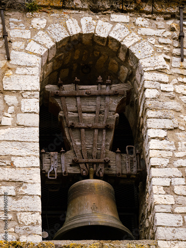 cloche et battant encadrée dans un clocher d'église médiévale en provence photo