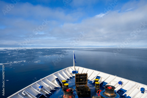 Bow of an arctic cruise ship on a sunny day in the high arctic, melting ice at the edge of the ice pack in the arctic ocean, signs of global warming and climate change 