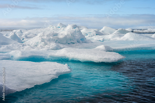 Melting ice at the edge of the ice pack in the arctic ocean, ice bergs floating in the ocean in the far north, signs of global warming and climate change 