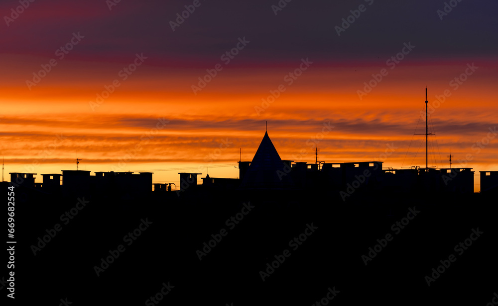 Cityscape Silhouette at Dusk with Vibrant Colors. A view of a city skyline at sunset