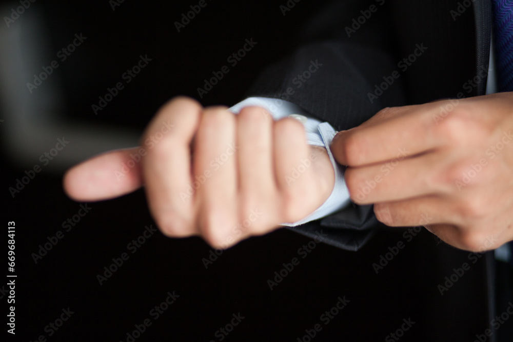 Obraz premium Close-up of Man's Hands Adjusting Shirt Cuff Underneath Suit Jacket