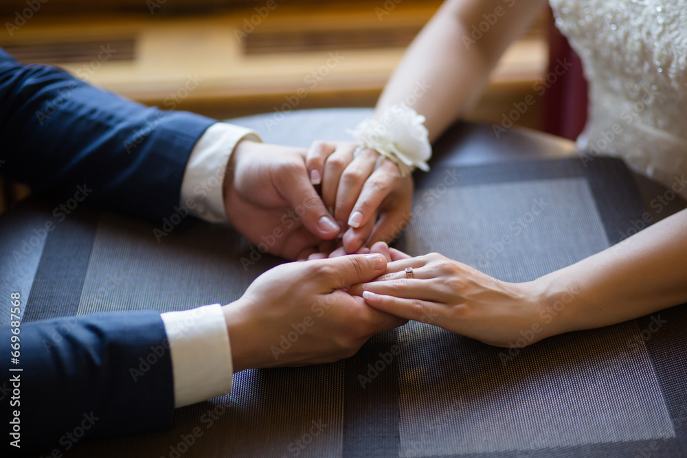 Obraz premium Bride and Groom's Hands Together on a Table